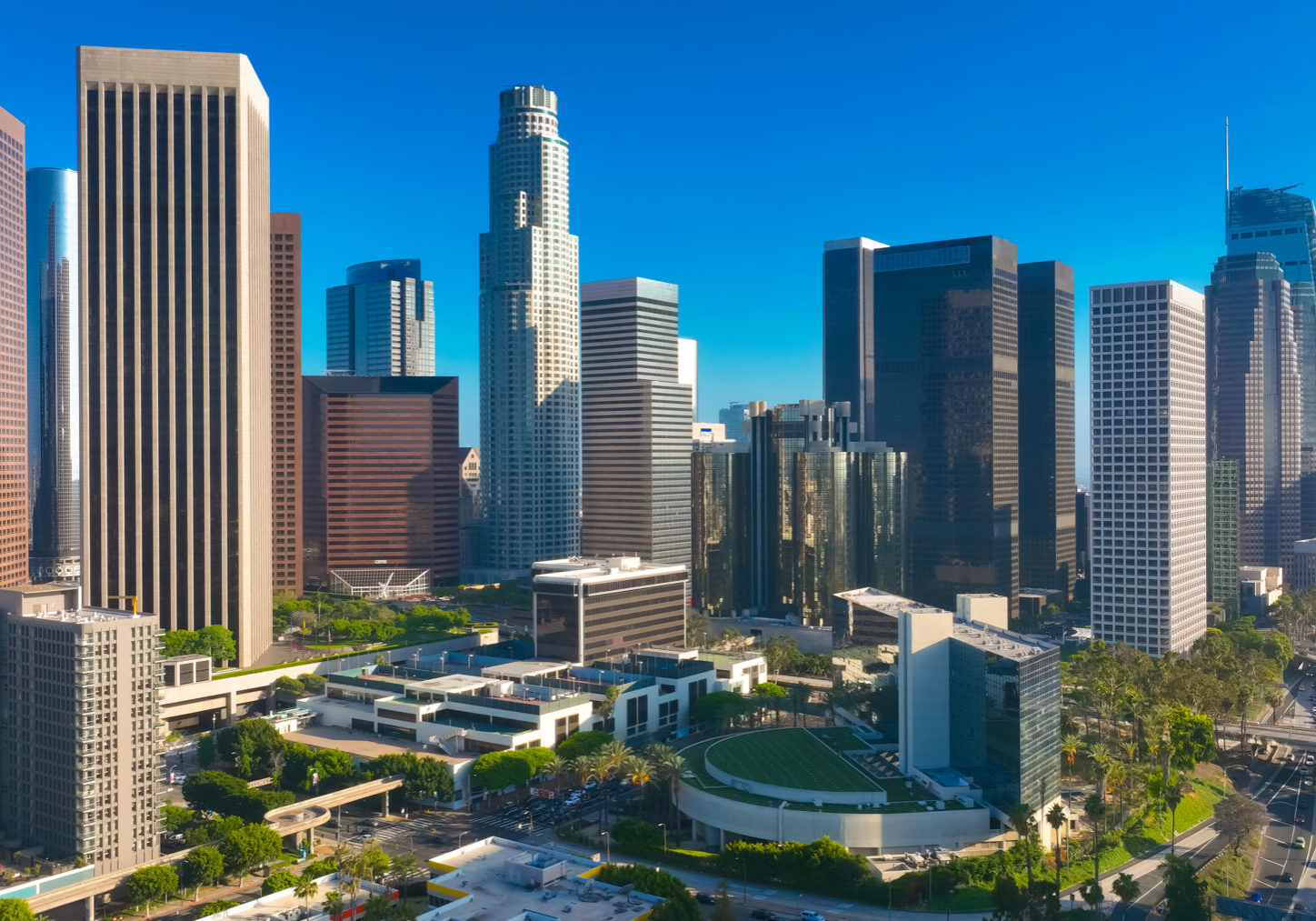 Los Angeles city. LA downtown aerial view. Los Angeles skyline. LA streets. Los Angeles from a top view. Downtown towers of Los Angeles. Panoramic scene of LA skyline. Blue sky frames the city below
